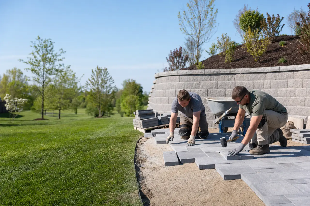A landscaping crew setting pavers for a new patio